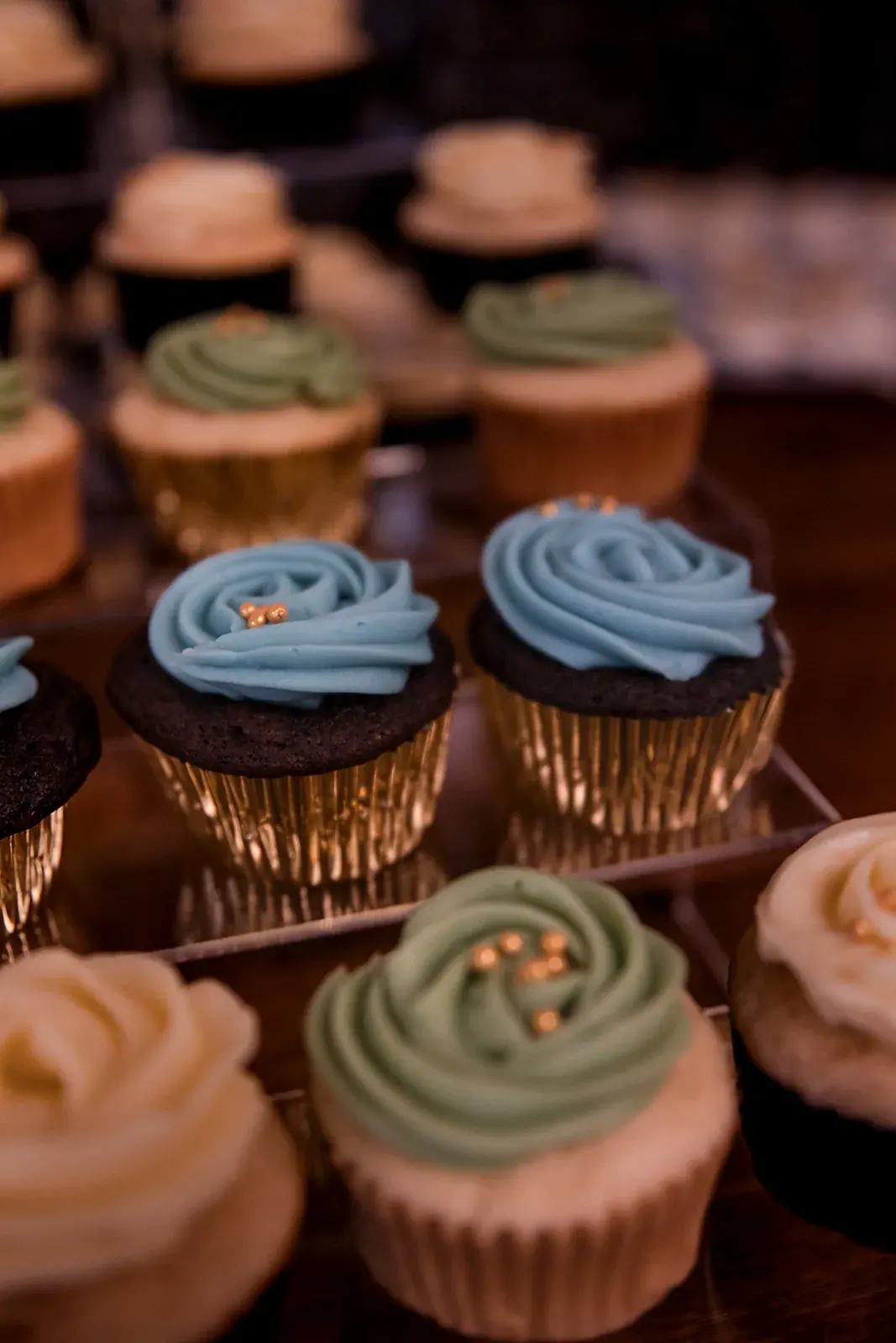 Wedding cupcakes with blue and sage frosting on the dessert table
