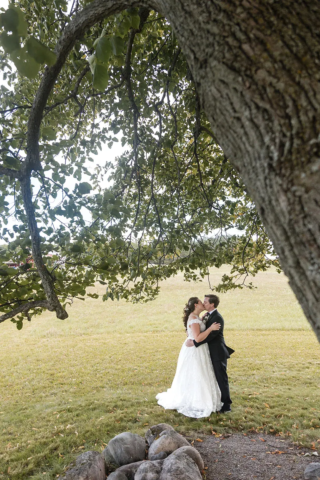 Bride and groom kiss under oak tree — Amelia & Howard's wedding at Sunset Hill Wedding Barn, Central Lake