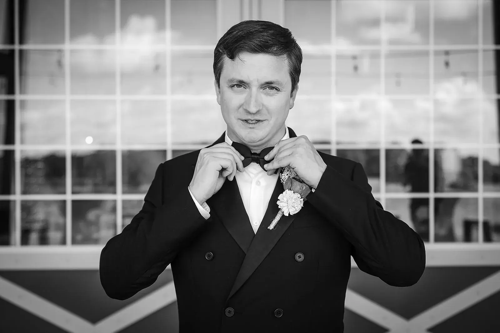 Groom adjusting bow tie in black and white — Amelia & Howard's wedding at Sunset Hill Wedding Barn, Central Lake