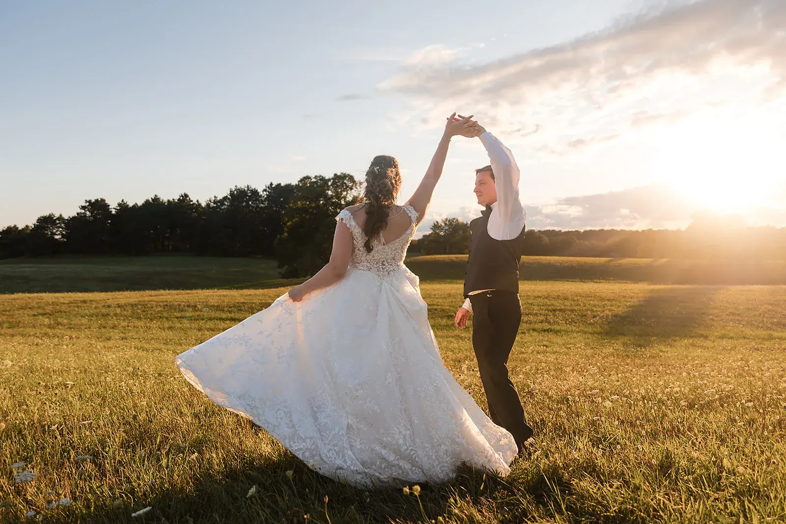 Groom twirling bride field sunset — Amelia & Howard's wedding at Sunset Hill Wedding Barn, Central Lake