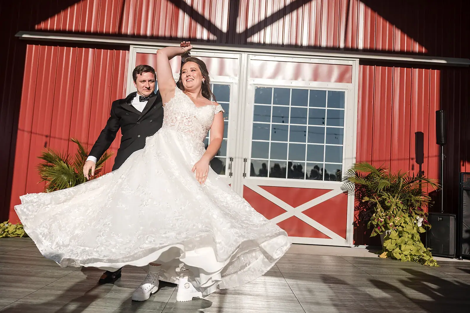 Groom twirling bride red barn — Amelia & Howard's wedding at Sunset Hill Wedding Barn, Central Lake
