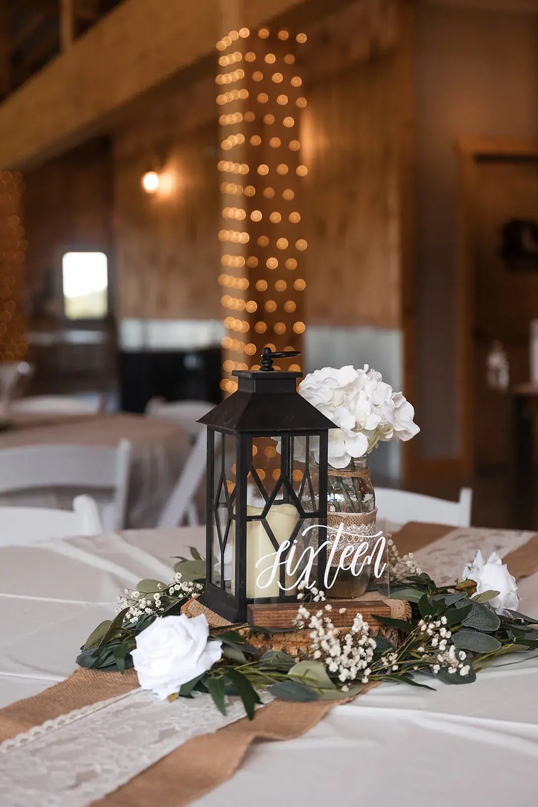 Reception table lantern centerpiece — Amelia & Howard's wedding at Sunset Hill Wedding Barn, Central Lake