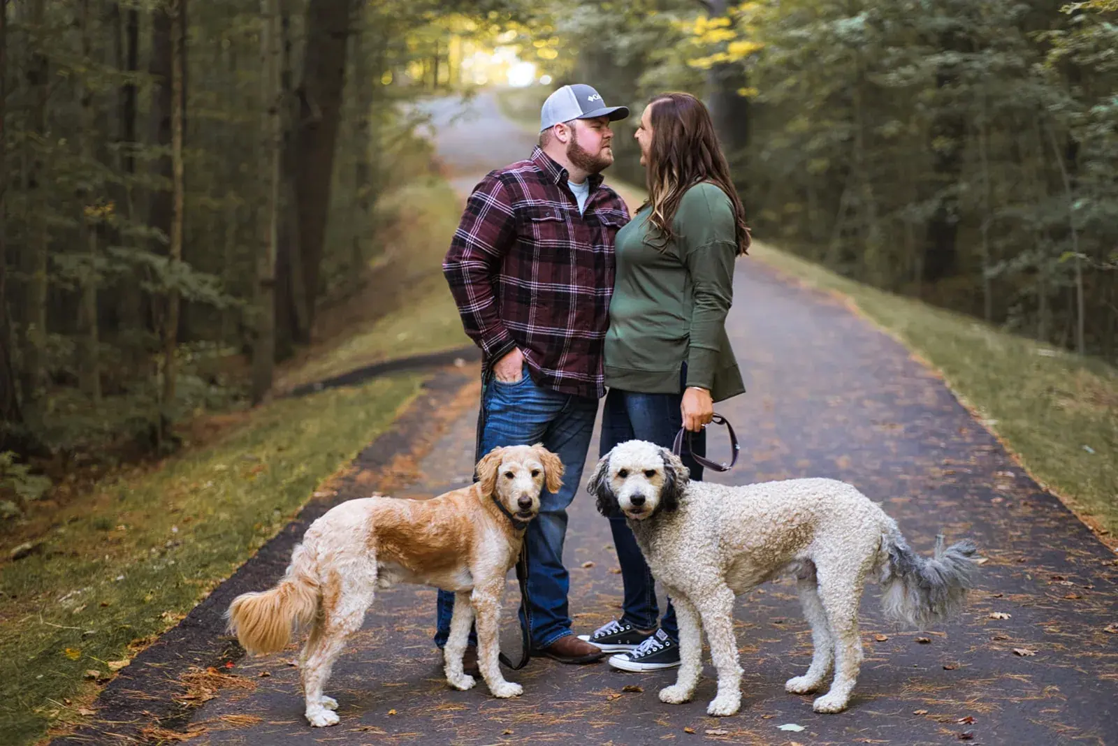 Couple kiss dogs wooded trail — Chelsea & Jake's engagement session at Aspen Park, Gaylord