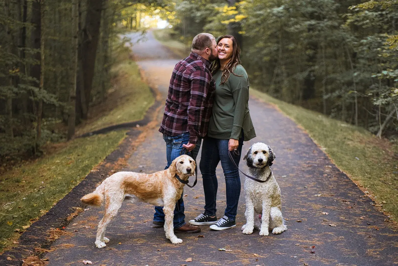 Couple with dogs wooded trail — Chelsea & Jake's engagement session at Aspen Park, Gaylord