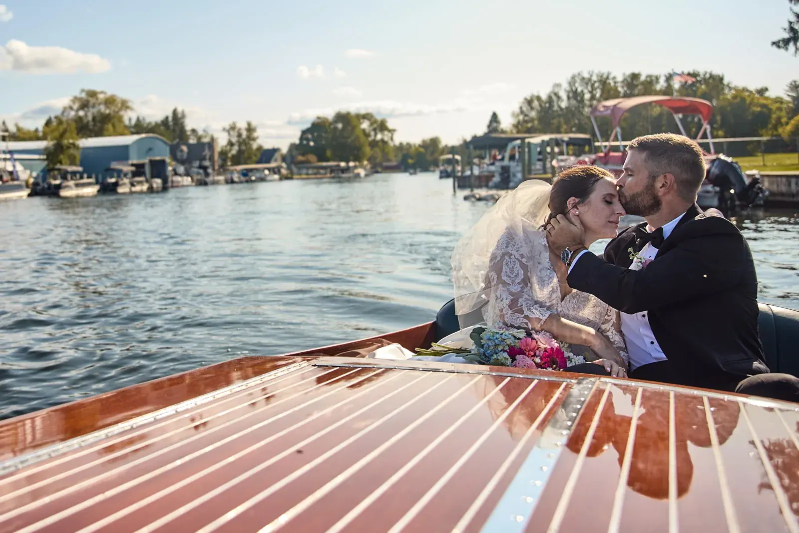 Bride and groom kiss antique boat river — Claire & Nick's wedding at Howe Marine, Indian River