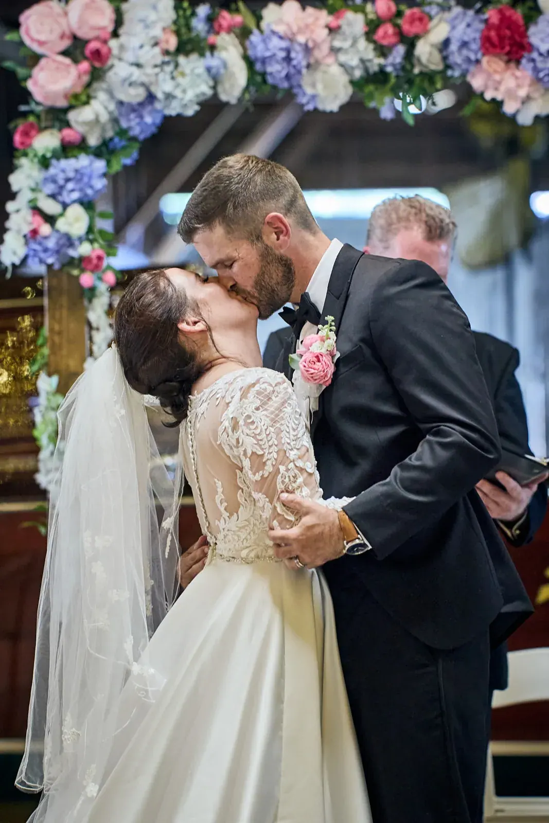 Ceremony kiss floral arch — Claire & Nick's wedding at Howe Marine, Indian River
