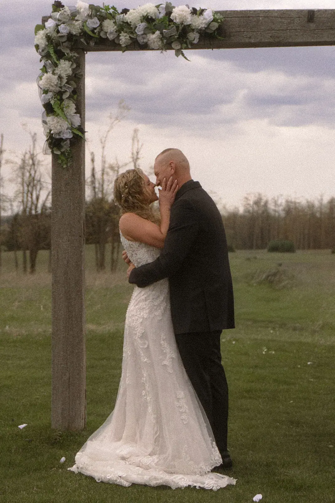 Bride and groom kiss ceremony arbor — Erin & Jim's wedding at Sonshine Barn, Gaylord