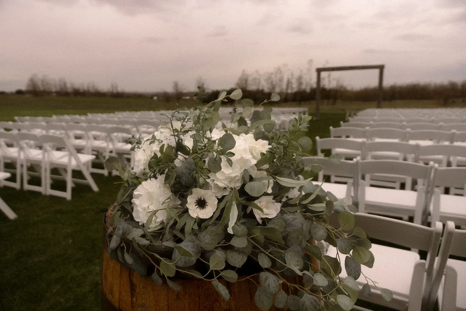 Ceremony chairs floral barrel — Erin & Jim's wedding at Sonshine Barn, Gaylord