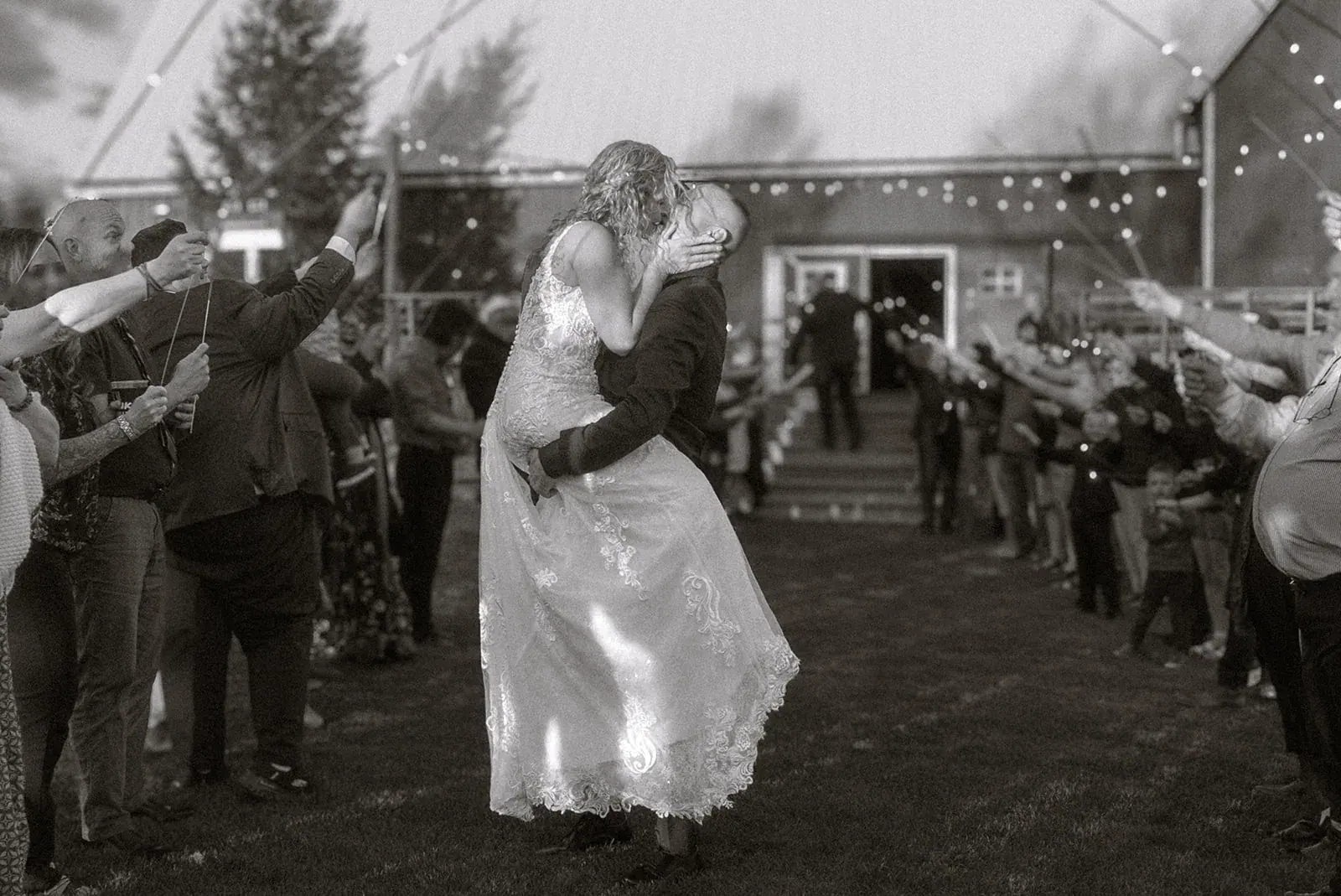 Grand exit guests cheering in black and white — Erin & Jim's wedding at Sonshine Barn, Gaylord