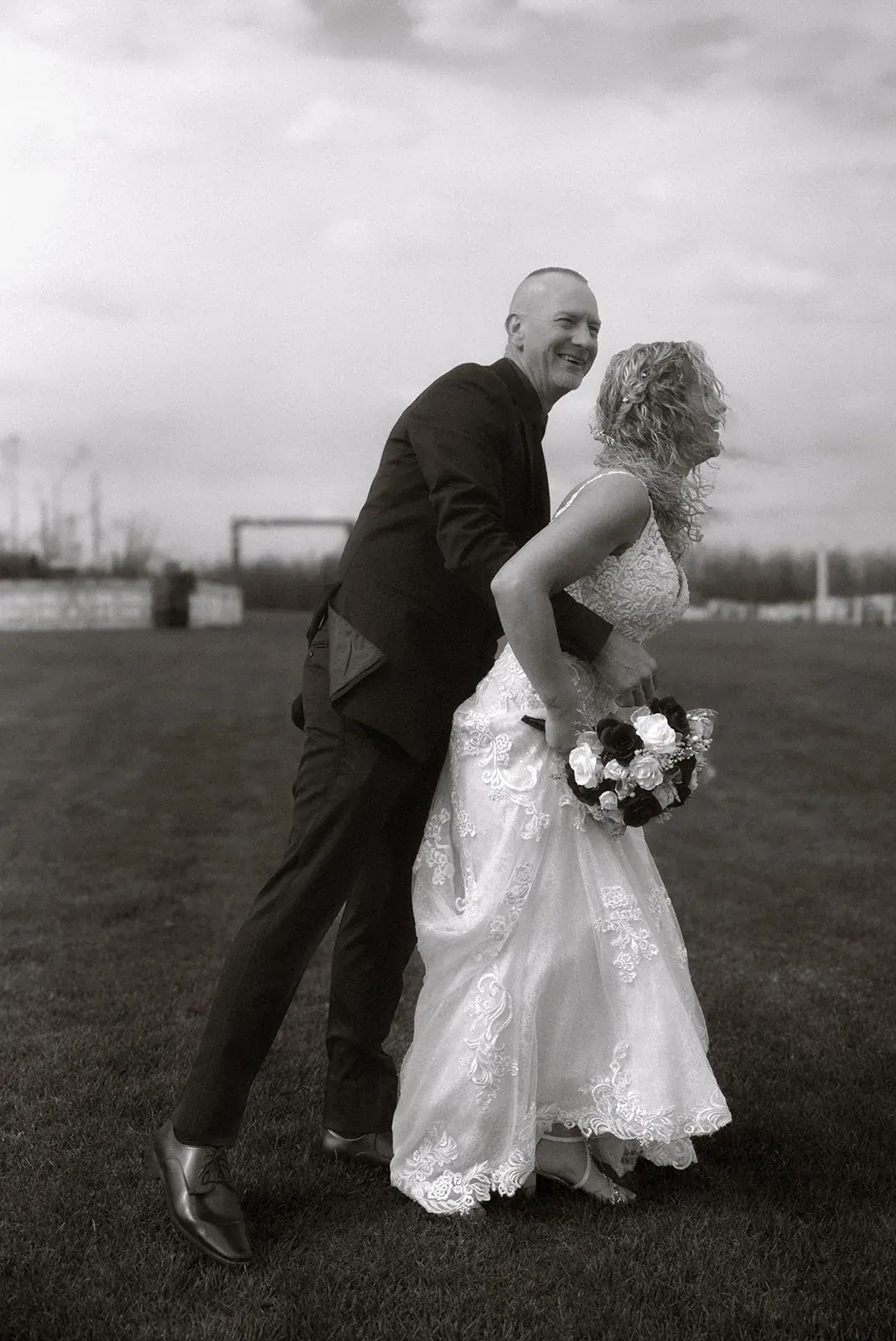 Groom kissing bride in black and white — Erin & Jim's wedding at Sonshine Barn, Gaylord
