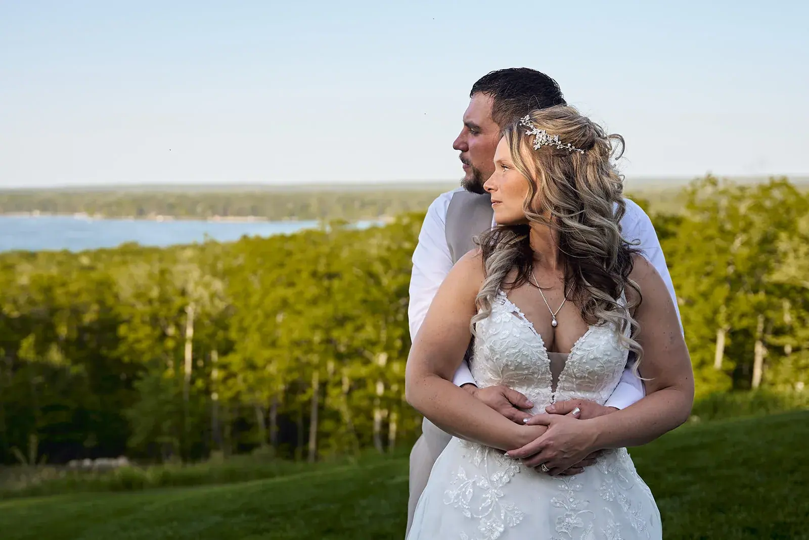 Bride and groom embracing on the lake overlook at The Manor at Fire Tower Hill