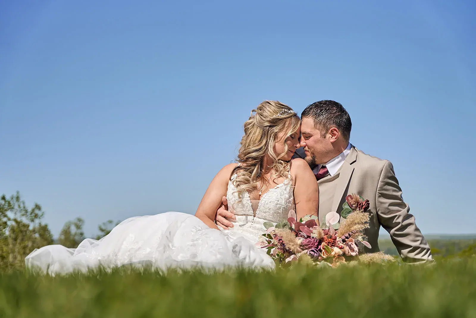 Bride and groom sitting grass lake view — Jess & Bryce's wedding at The Manor at Fire Tower Hill, Lewiston
