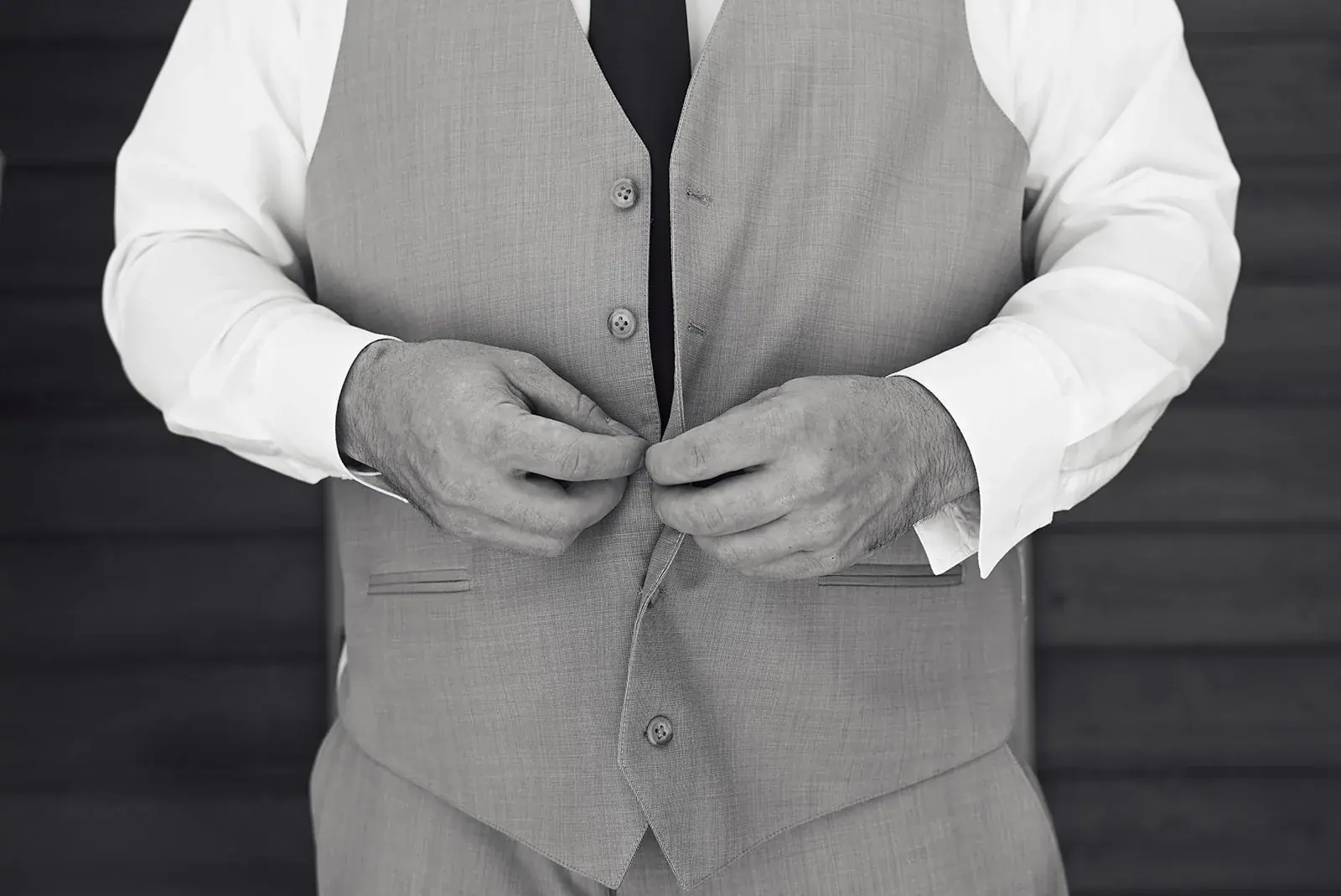 Groom buttoning vest in black and white — Jess & Bryce's wedding at The Manor at Fire Tower Hill, Lewiston