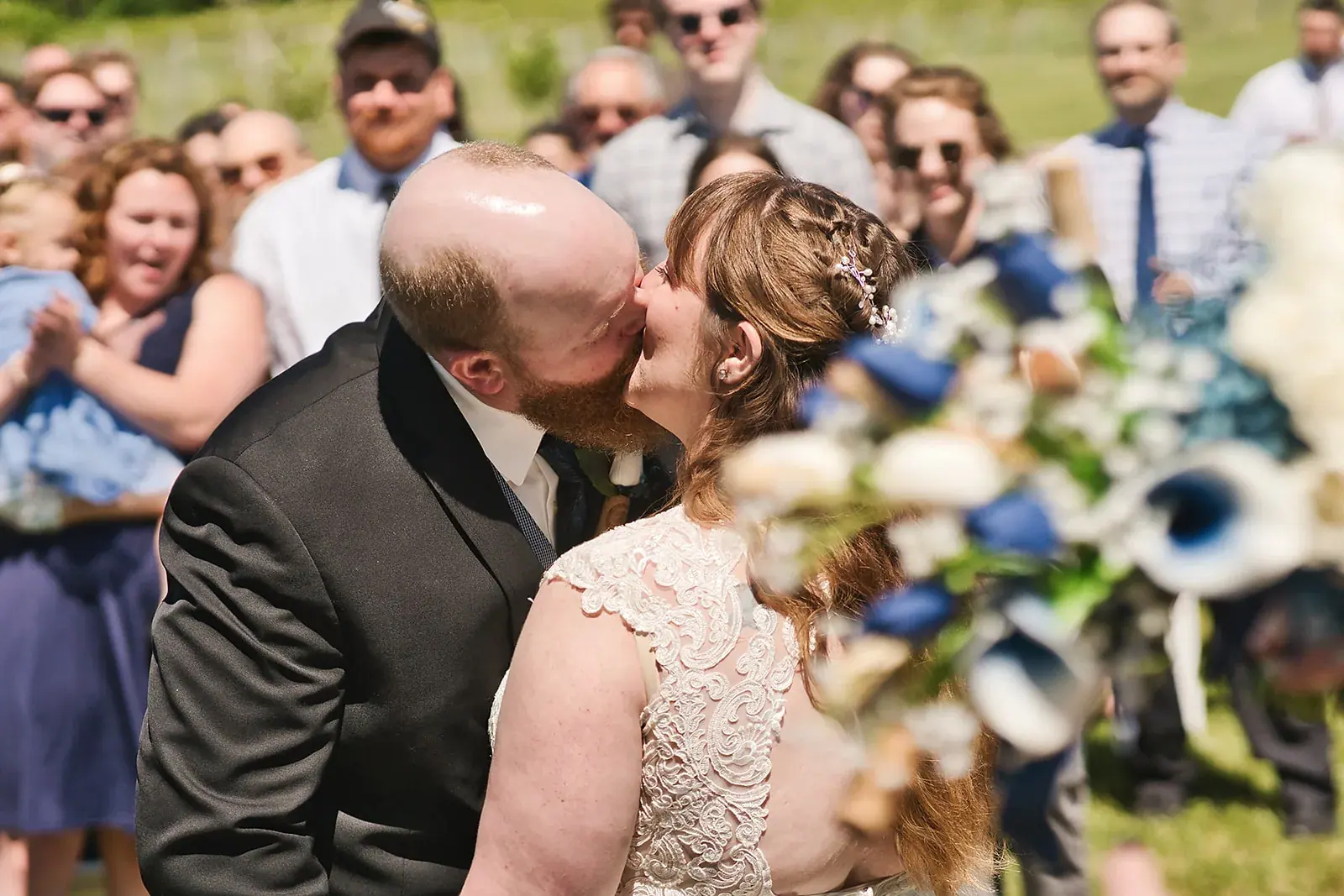Bride and groom kiss guests — Kayla & Robert's wedding at Mackinaw Trail Winery, Petoskey
