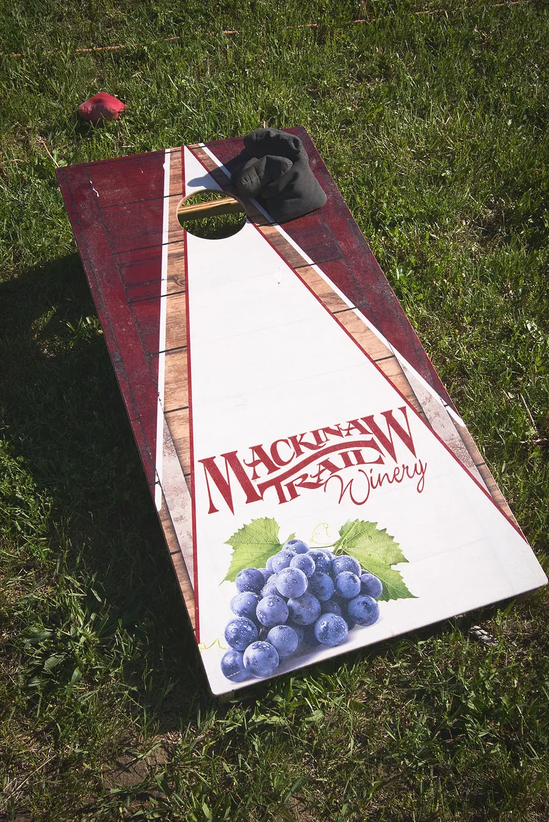 Cornhole board winery detail — Kayla & Robert's wedding at Mackinaw Trail Winery, Petoskey
