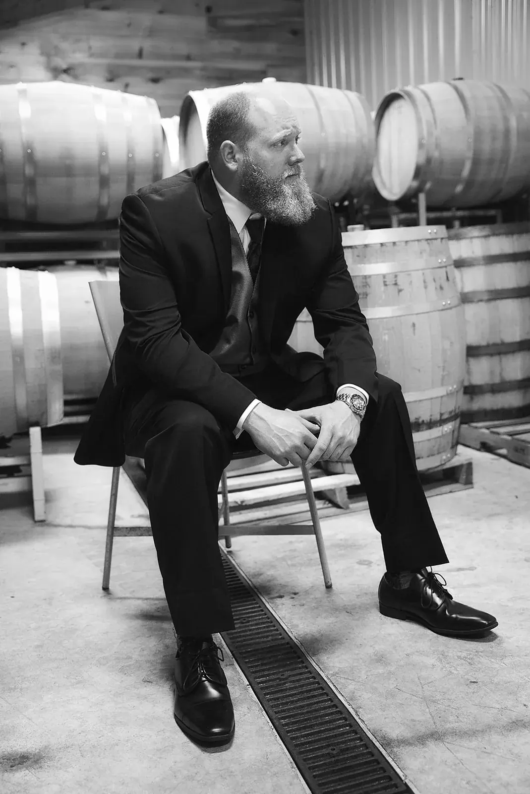 Groom barrel room in black and white — Kayla & Robert's wedding at Mackinaw Trail Winery, Petoskey