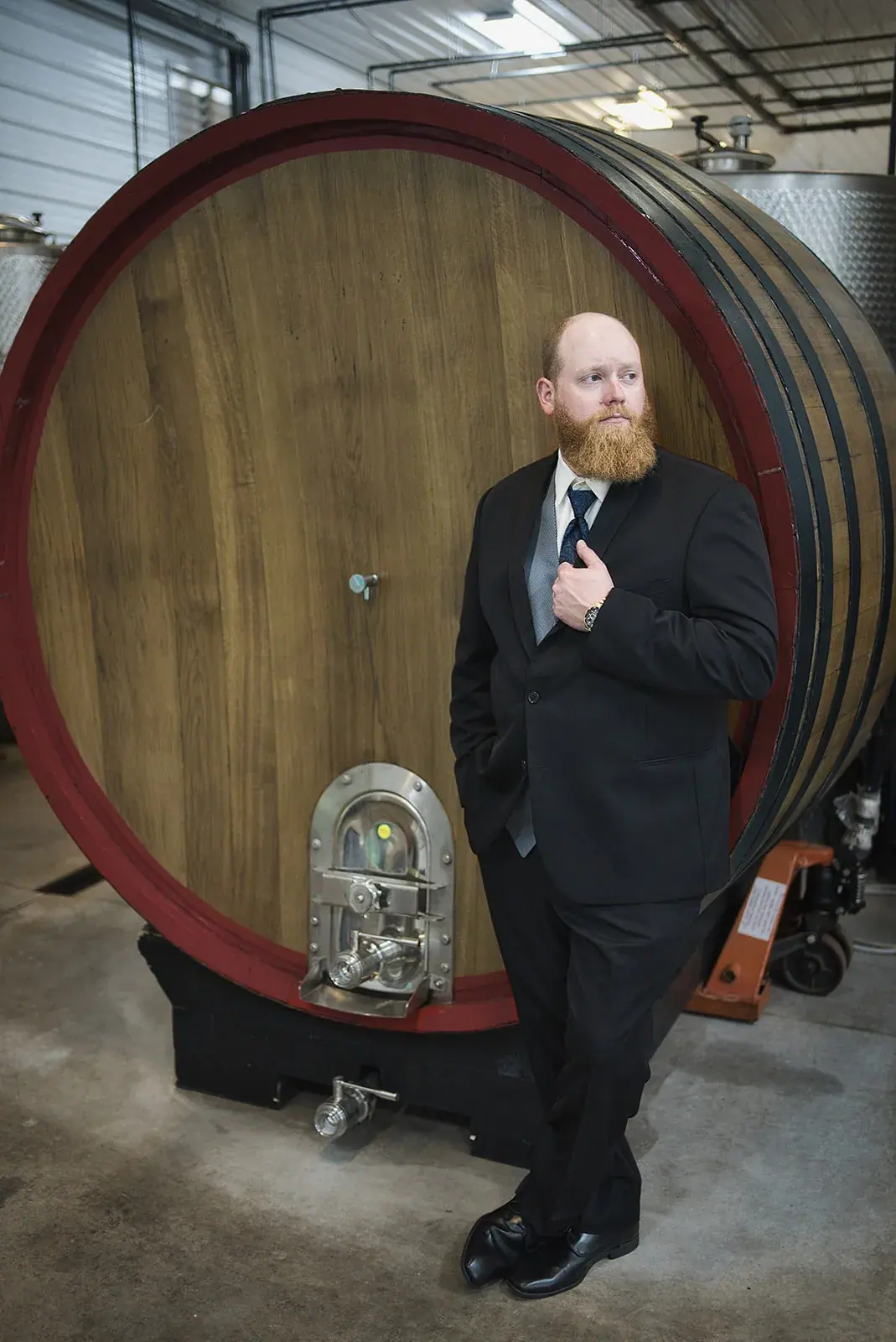 Groom wine barrel portrait — Kayla & Robert's wedding at Mackinaw Trail Winery, Petoskey