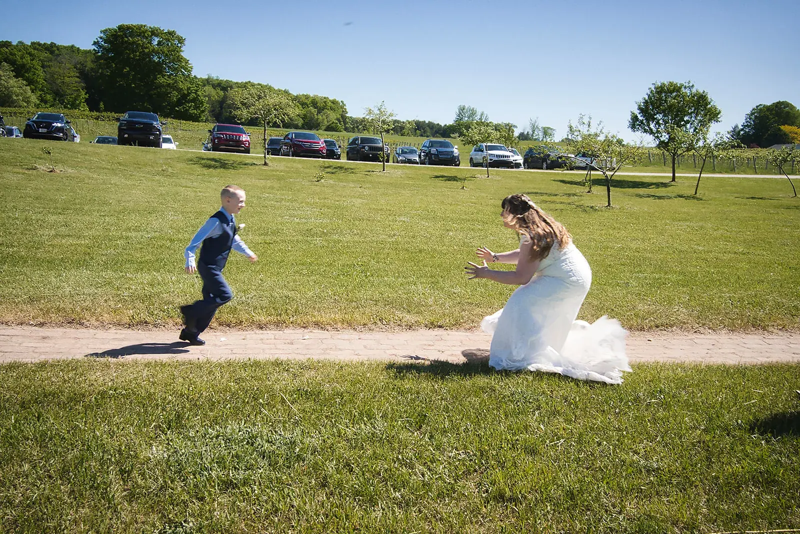 Ring bearer running vineyard — Kayla & Robert's wedding at Mackinaw Trail Winery, Petoskey