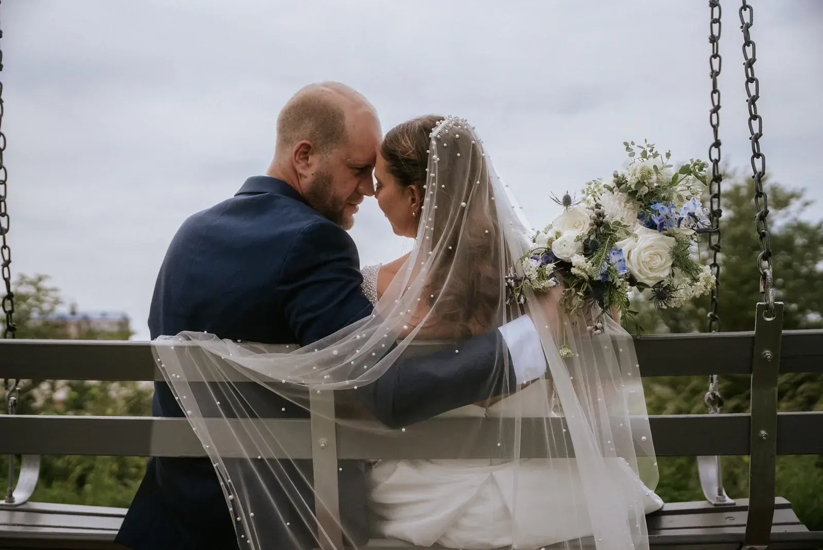 Bride and groom porch swing veil — Kelly & Ezra's wedding at Aria at The Whitcomb, St. Joseph