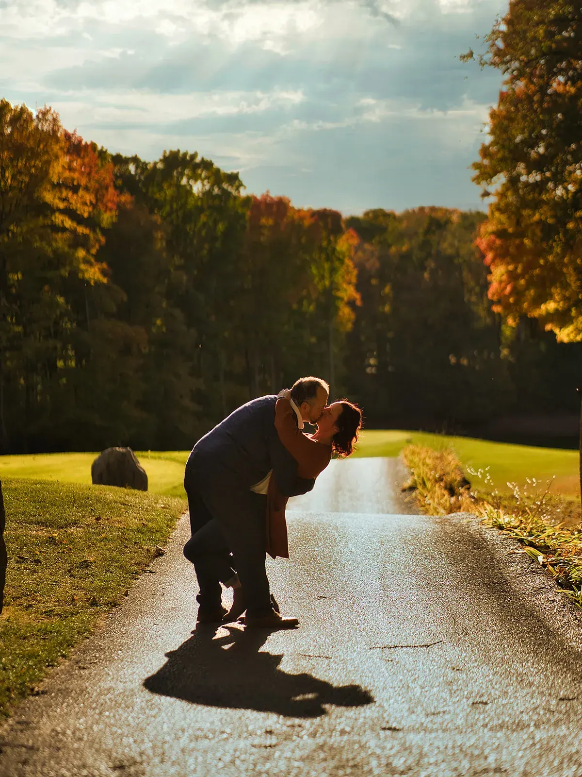 Dip kiss golf path sunset — Matt & Adrian's engagement session at Boyne Mountain Resort