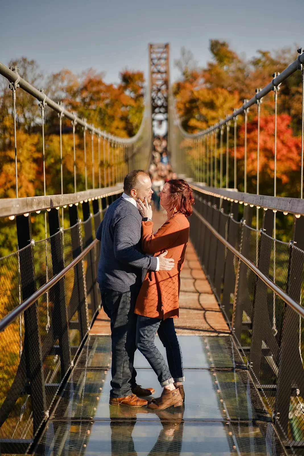 Skybridge glass floor embrace — Matt & Adrian's engagement session at Boyne Mountain Resort