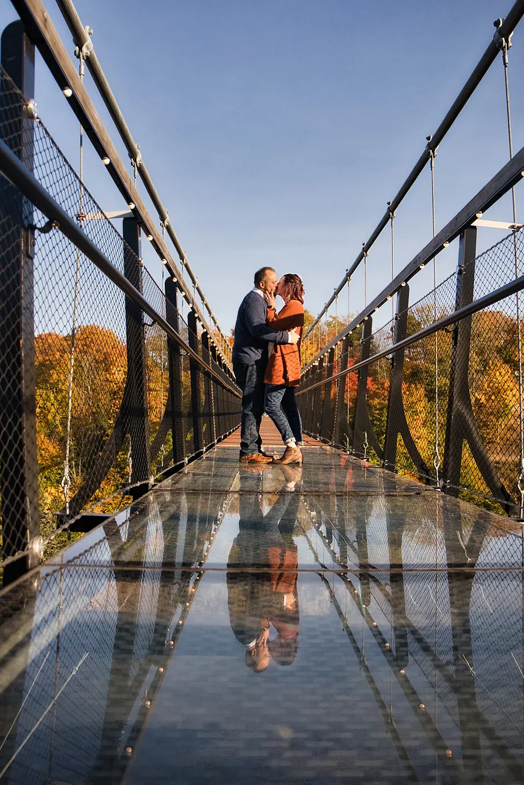 Skybridge glass floor reflection — Matt & Adrian's engagement session at Boyne Mountain Resort