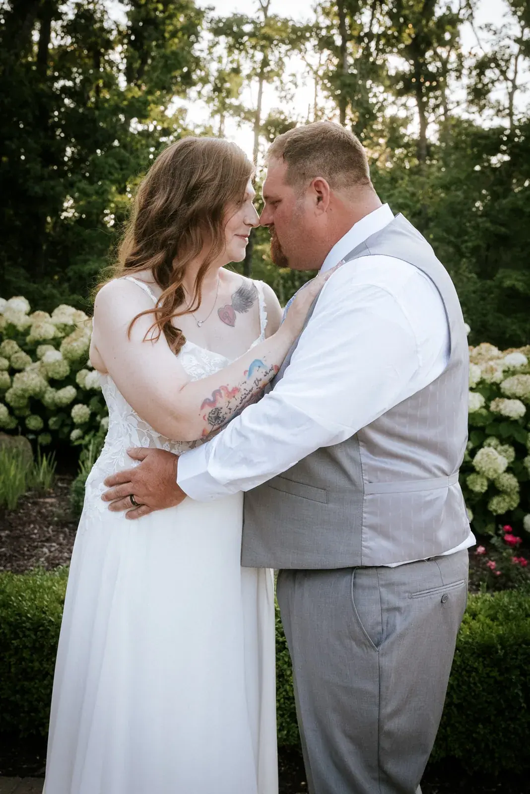 Bride and groom embrace hydrangeas — Patty & Nick's wedding at The Manor at Fire Tower Hill, Lewiston